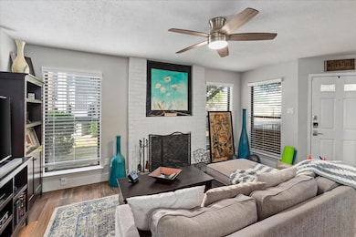 Living room with a textured ceiling, a fireplace,