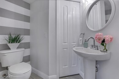 Half bathroom featuring toilet, tile patterned flo