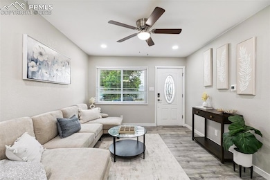 Living area featuring light wood-style floors, ceiling fan, baseboards, and recessed lighting