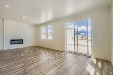 Unfurnished living room with a fireplace, a textured ceiling, light wood-style floors, and recessed lighting