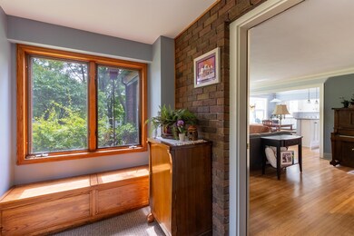Interior space with light wood-style floors and brick wall