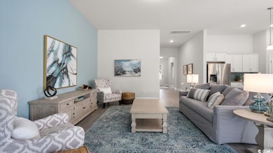 Living room featuring wood finished floors, baseboards, and recessed lighting