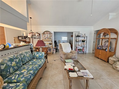 Living area with crown molding, vaulted ceiling, a