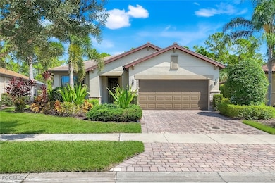 Single story home featuring decorative driveway, stucco siding, an attached garage, and a front lawn