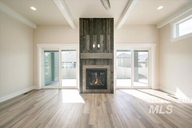 Unfurnished living room featuring beam ceiling, a fireplace, and wood finished floors