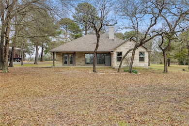 Back of house with french doors, a chimney, stone
