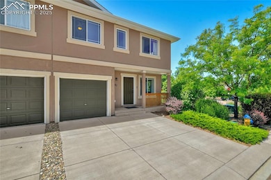 Multi unit property featuring covered porch, stucco siding, driveway, and a garage