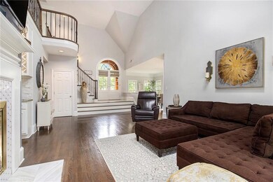 Living room featuring stairs, wood finished floors, and high vaulted ceiling
