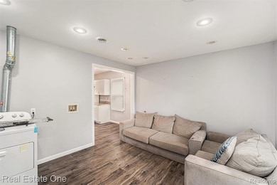 Living area featuring washer / clothes dryer, dark wood-style flooring, and recessed lighting