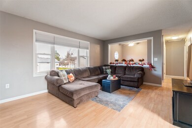 Living room with light wood finished floors, a textured ceiling, and a ceiling fan