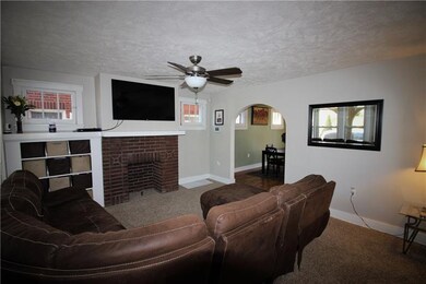 The living room features the original gas fireplac