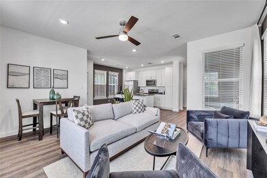 Living room with a ceiling fan, recessed lighting,