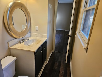 Half bathroom featuring dark wood-style floors and vanity