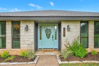 Property entrance with stone siding and roof with