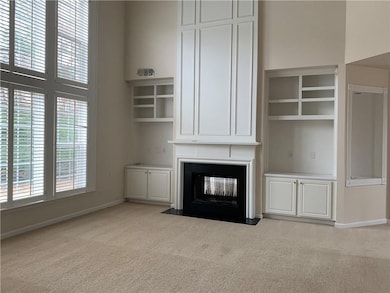 Unfurnished living room with light carpet, plenty of natural light, and a multi sided fireplace