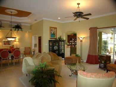 Living Room - Formal living and dining areas with crown molding, 11 ft tray ceilings and sliding doors to the lanai.