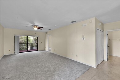 Empty room with light carpet, ceiling fan, and light tile patterned flooring