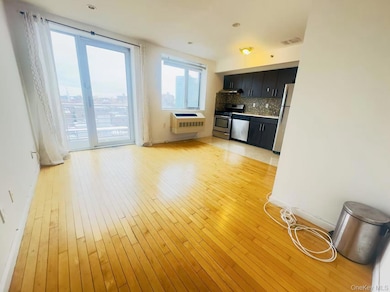 Kitchen featuring stainless steel appliances, visible vents, decorative backsplash, light wood-style floors, and dark cabinetry