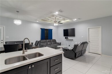 Kitchen with visible vents, recessed lighting, a sink, decorative light fixtures, and ceiling fan with notable chandelier