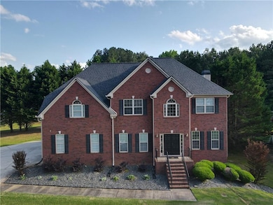 Colonial-style house featuring a chimney and brick siding