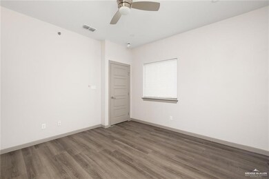 Spare room featuring wood finished floors, baseboards, and a ceiling fan
