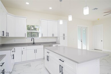 Kitchen with hanging light fixtures, sink, a cente