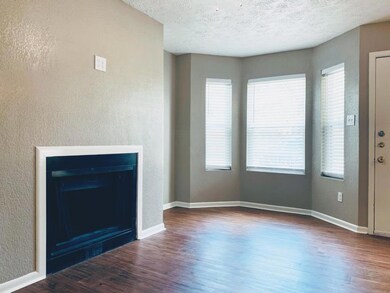 Unfurnished living room featuring baseboards, wood