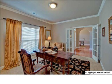Just off the Foyer, is an office or living room with French doors, beautiful full windows and elegant detailing.