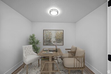 AI: Sitting room with wood finished floors, a textured ceiling, and a desk