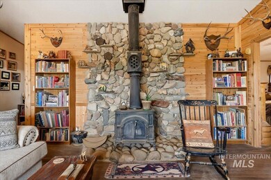 Living room featuring a wood stove, wood walls, and wood finished floors
