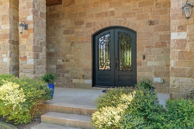 Property entrance with stone siding and french do
