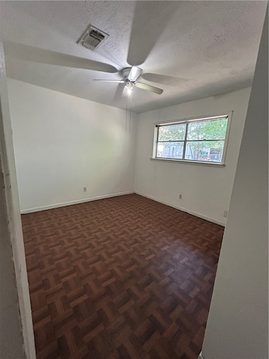 Empty room featuring a textured ceiling and ceiling fan
