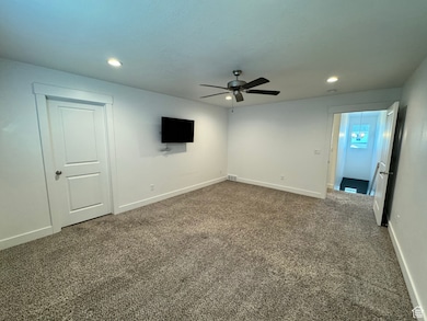 Carpeted spare room with a ceiling fan and recessed lighting