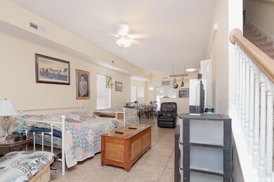 Living room with ceiling fan and tile patterned fl