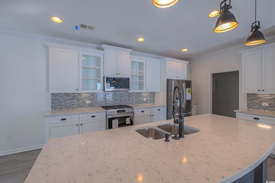 Kitchen with white cabinets, hanging light fixture