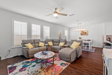 Living area featuring a ceiling fan, dark wood-st