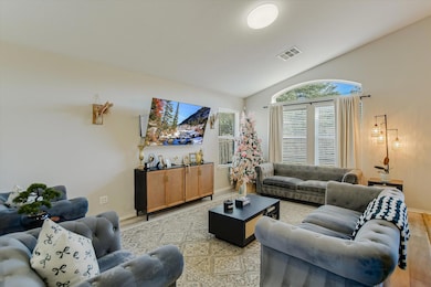 Living area featuring vaulted ceiling and light wood-style flooring