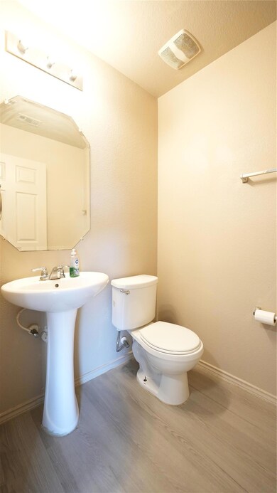 Bathroom featuring wood finished floors, toilet, 