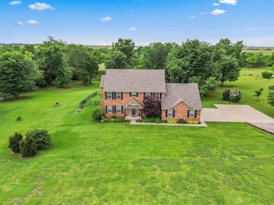 View of front of house with a front yard, brick siding, and a shingled roof