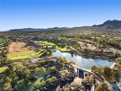 Aerial view of property and surrounding area with nearby suburban area, a local golf course, and a water and mountain view