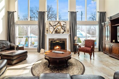 Stunning wall of windows surround the gas fireplace, lovely ceramic tile flooring.