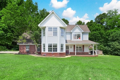 Victorian house featuring a front lawn, a porch, roof with shingles, brick siding, and cooling unit