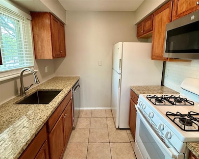 Kitchen with stainless steel appliances, brown ca