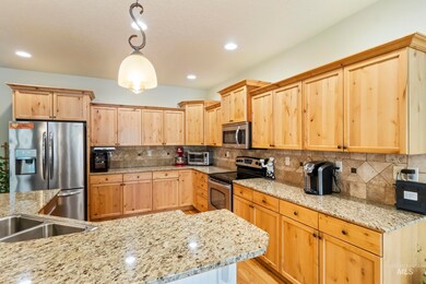 Kitchen with stainless steel appliances, light brown cabinets, backsplash, and recessed lighting