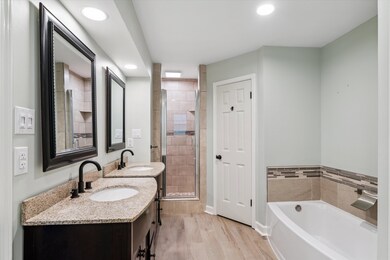 Bathroom featuring wood-type flooring, dual vanity