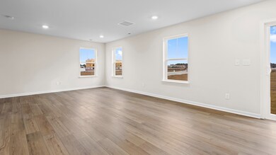 Living room with multiple large windows in a DRB Homes Glenshaw plan at The Village of College Park.