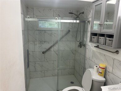 Bathroom with tile walls, a shower with shower doo
