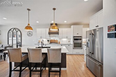 Kitchen featuring stainless steel appliances, light countertops, backsplash, white cabinetry, and recessed lighting