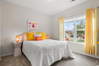 Bedroom featuring carpet and baseboards