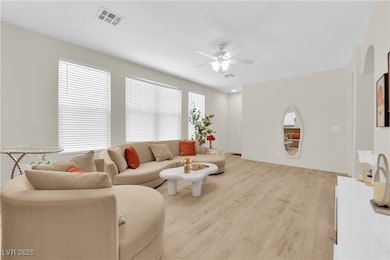 Living area featuring a ceiling fan and light wood